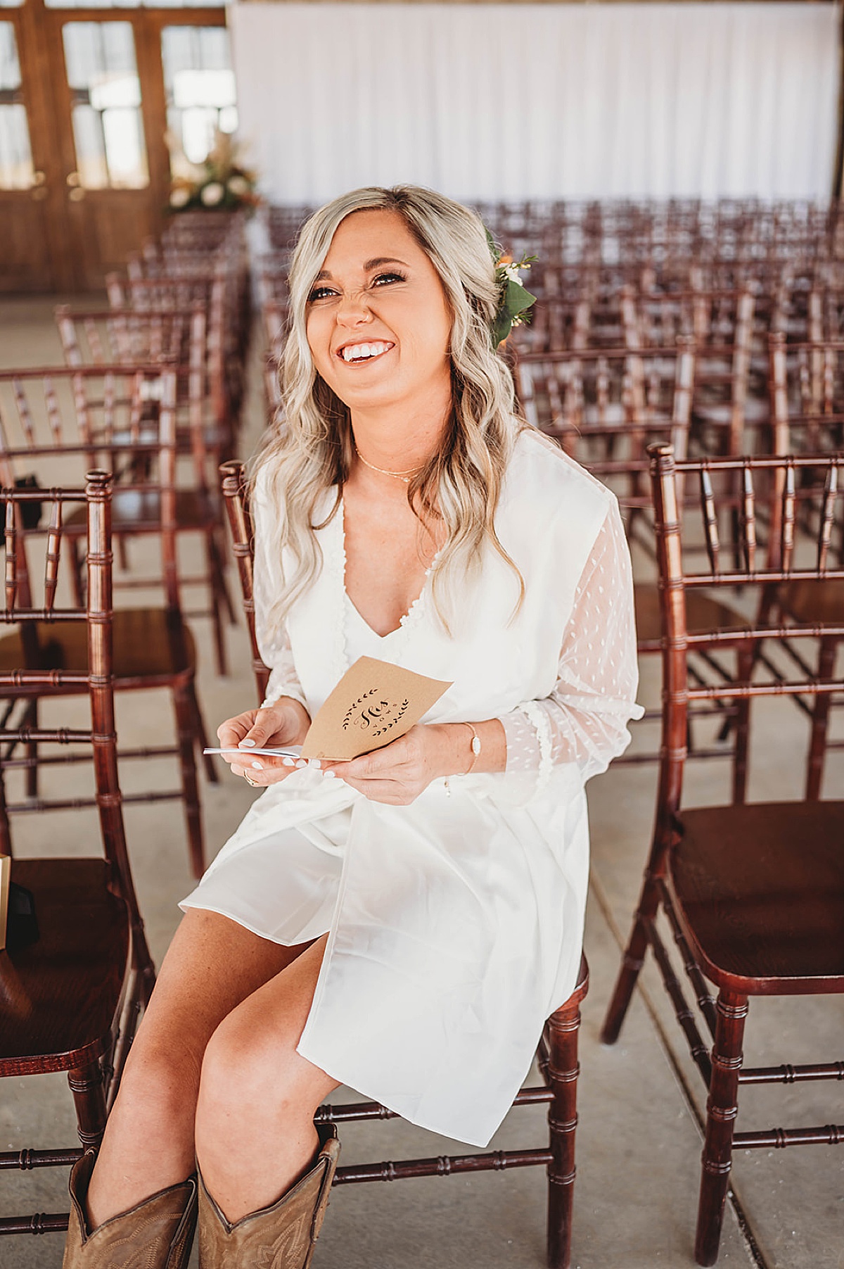 Brie smiles as she reads the groom's vows while getting ready for boho prairie wedding