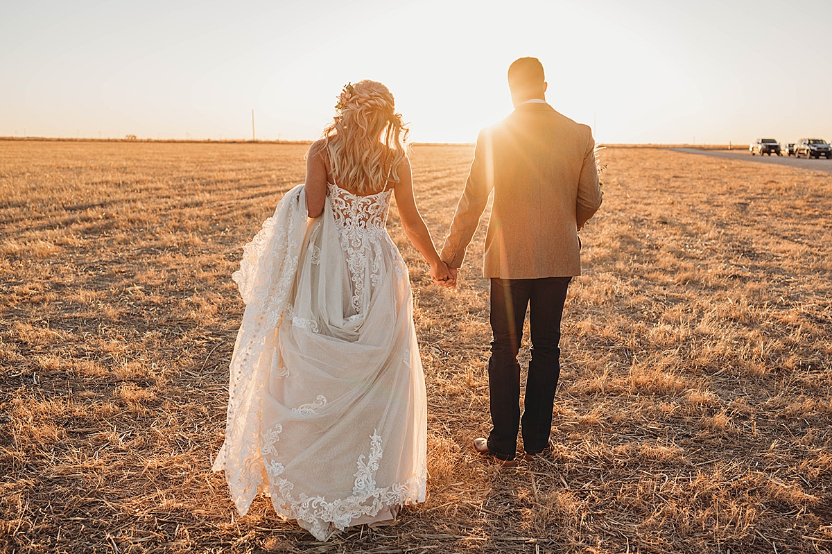 Bride and groom walk into the prairie sunset at boho wedding shot by palo duro canyon elopement photographer