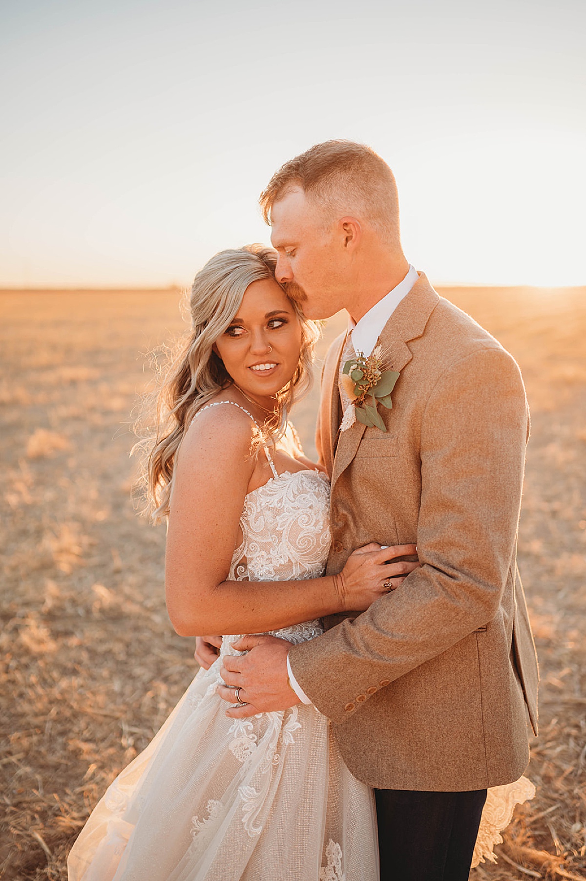 bride and groom with boho boutonniere pose in prairie field during golden hour at amarillo wedding shot by palo duro canyon elopement photographer 