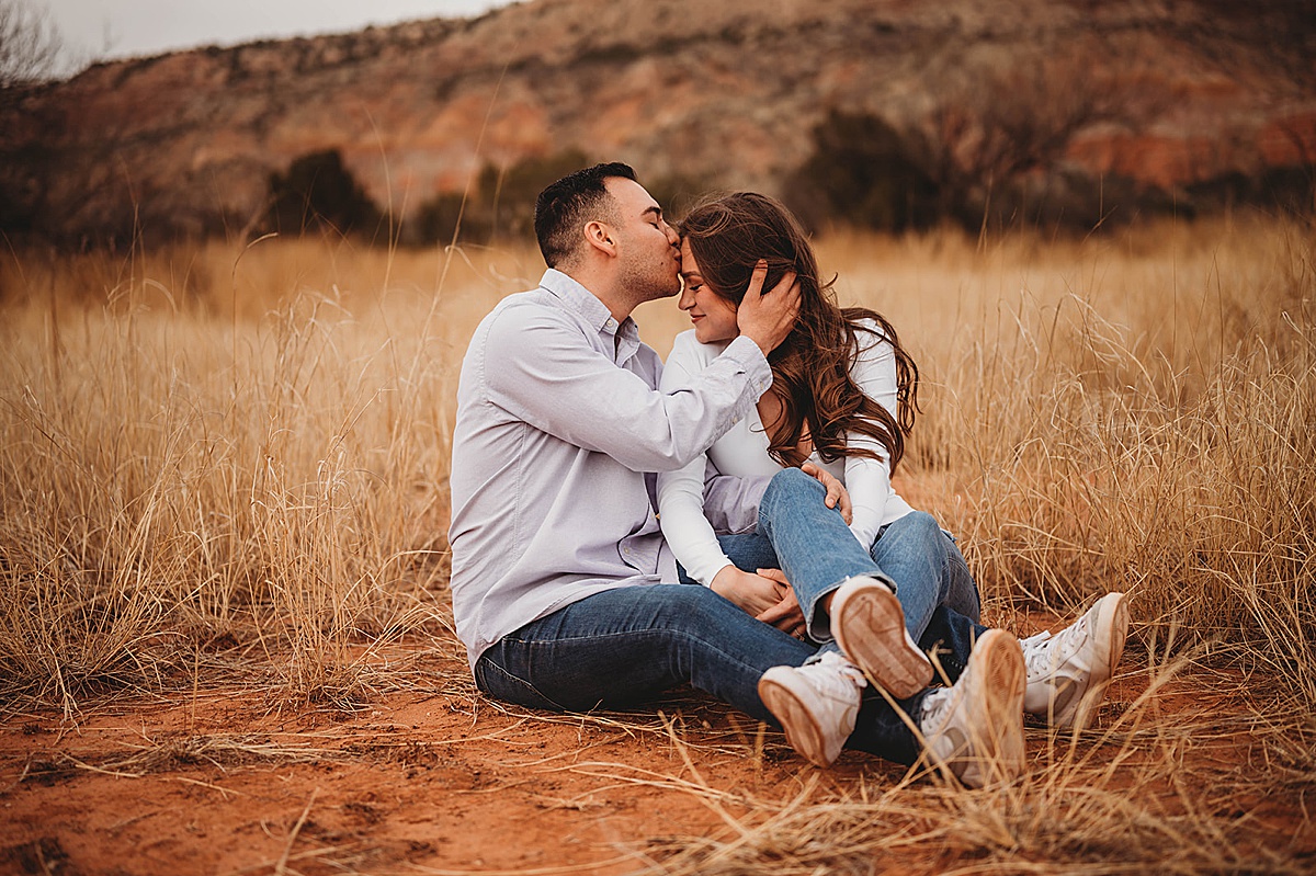 man kisses his fiancee's forehead in rugged canyon engagement shoot by Three Feather Photo Co