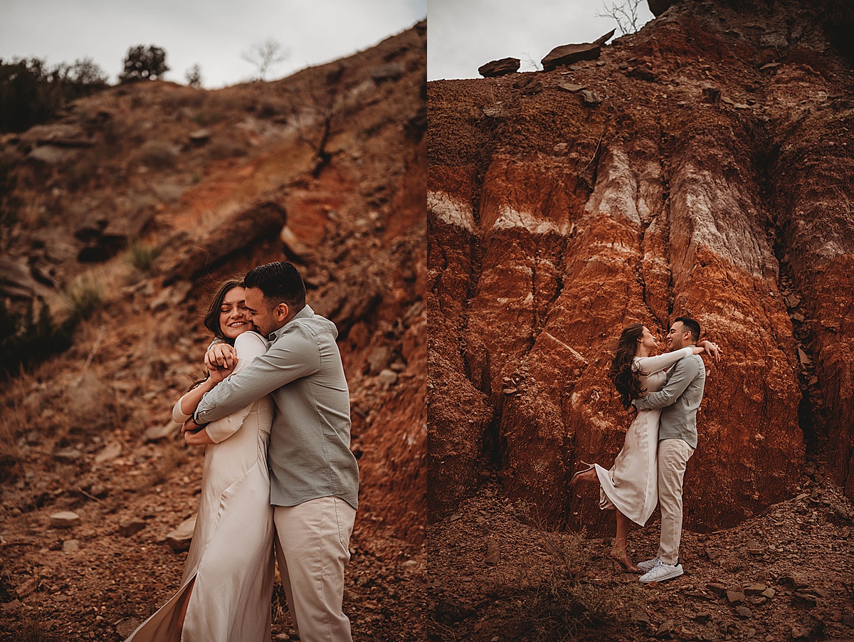 couple embraces and smiles with red rock background at adventure engagement shoot by Three Feather Photo Co