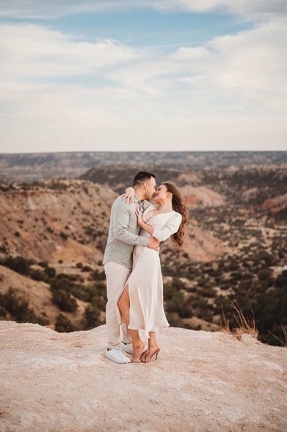 man and woman share romantic kiss on sweeping vista shot by Palo Duro Canyon Elopement Photographer