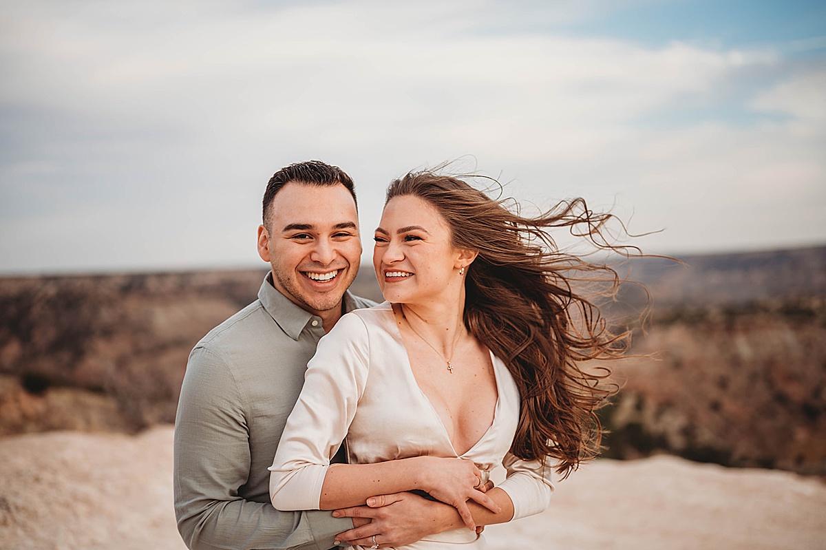 classy couple pose in front of grand clifftop view in engagement shoot by Palo Duro Canyon Elopement Photographer