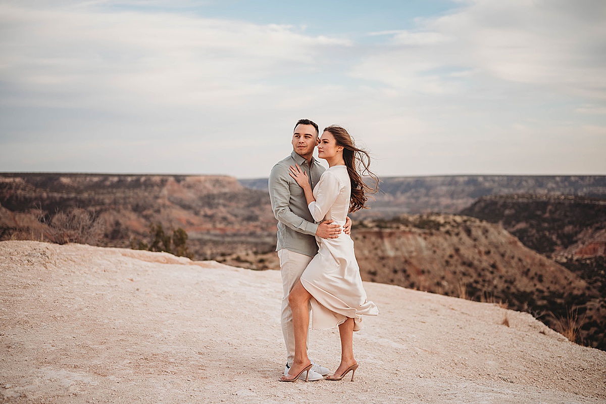 newly engaged couple pose in front of dramatic west texas view shot by Palo Duro Canyon Elopement Photographer