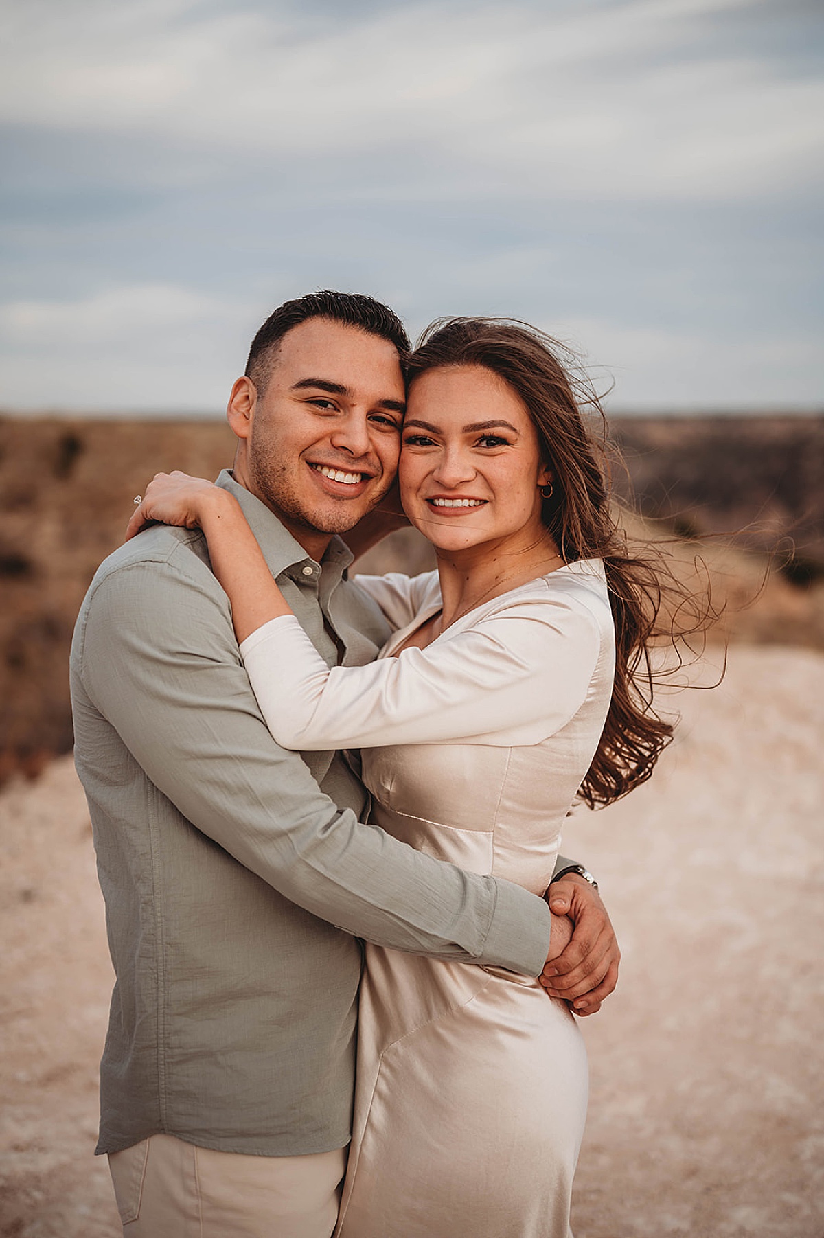 engaged couple smile with west texas vista in background shot by Palo Duro Canyon Elopement Photographer