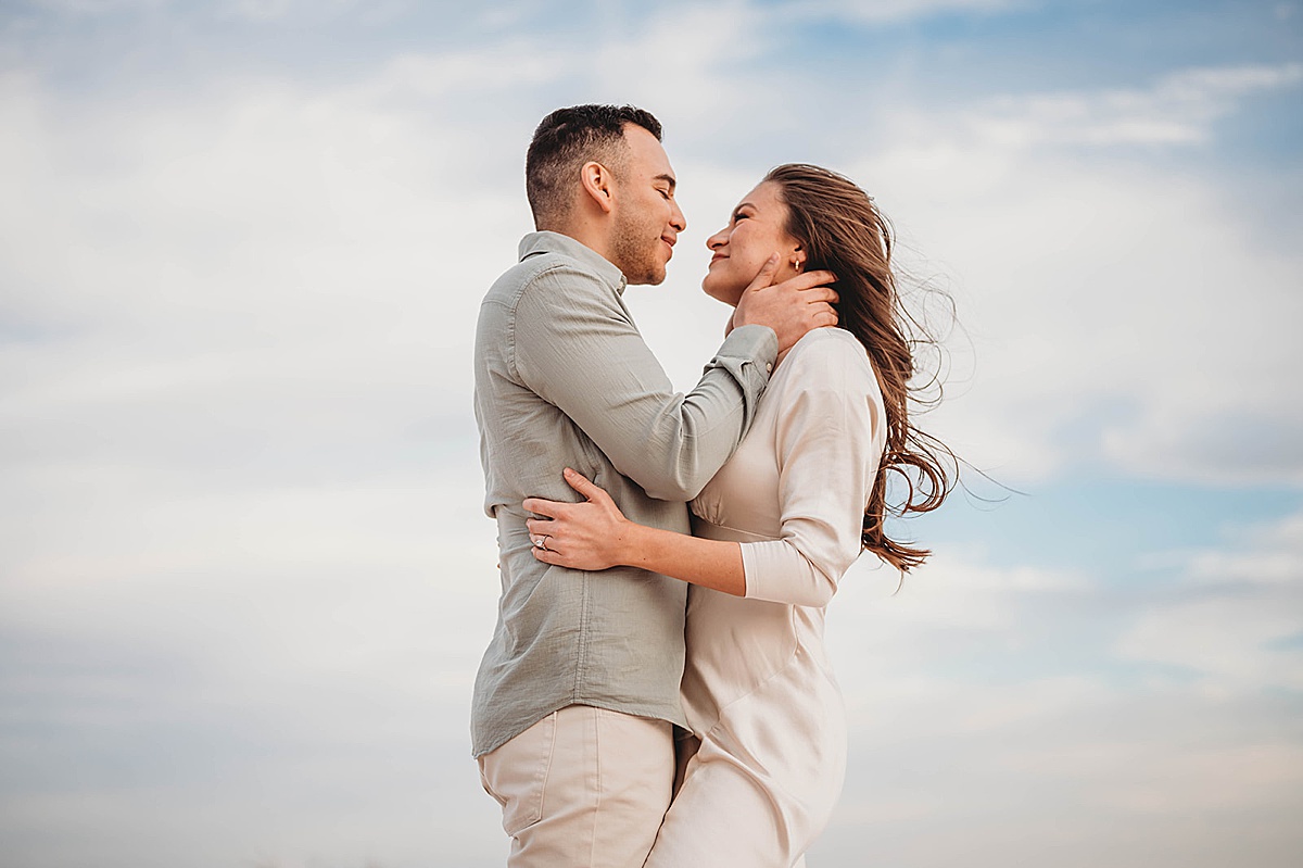 newly engaged couple embrace in front of west texas blue sky in shoot by Palo Duro Canyon Elopement Photographer