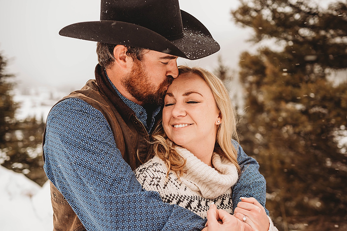 man kisses fiancee on the forehead in new mexico western winter engagement shoot