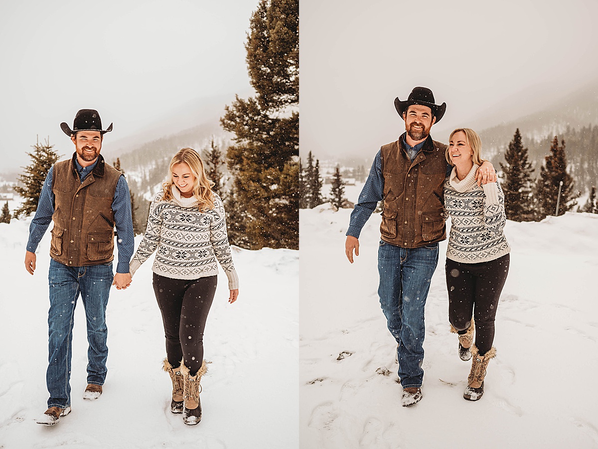 fiances walk through the snow wearing hat and sweater in western winter engagement shoot