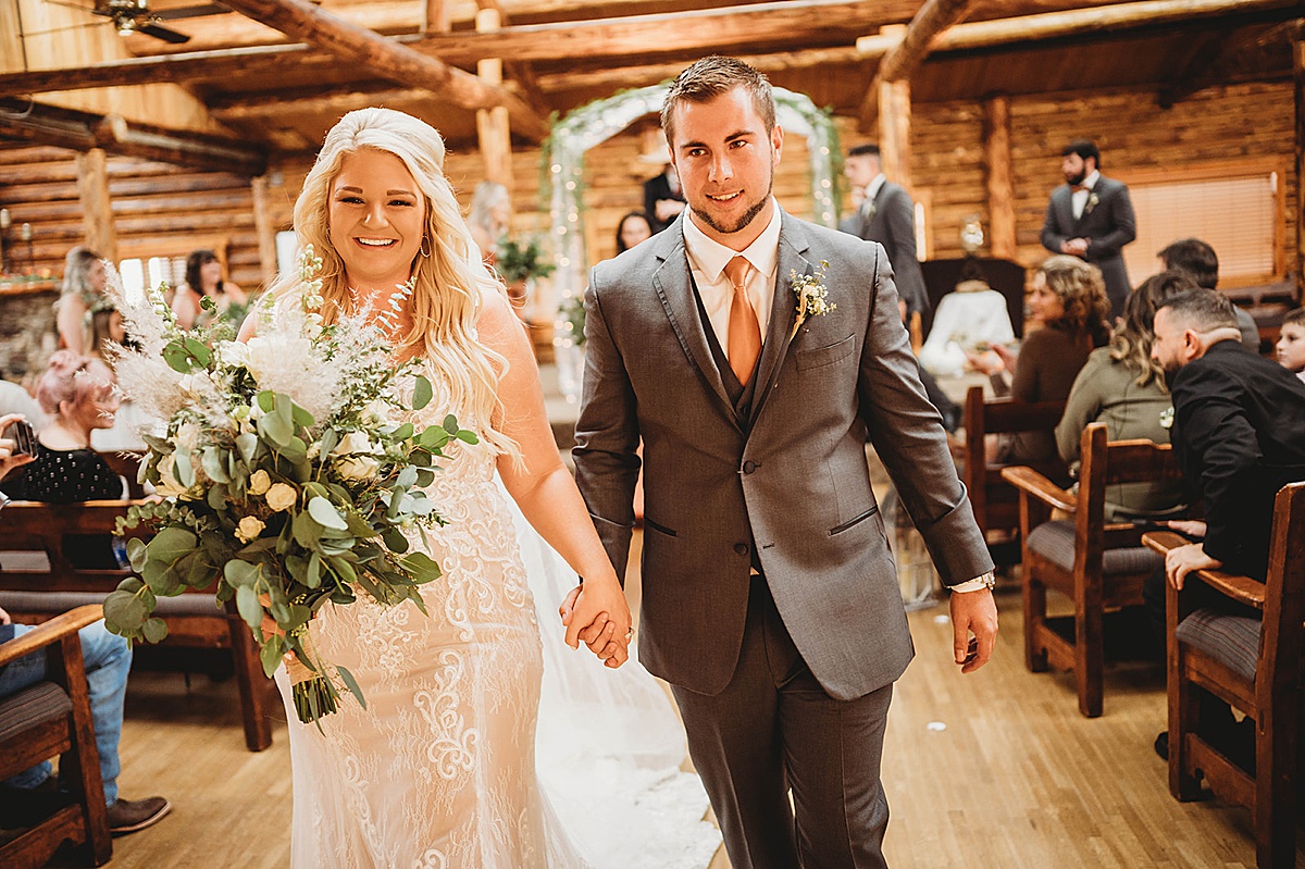 Newlywed bride and groom walk down the aisle after wedding shot by Three Feather Photo Co