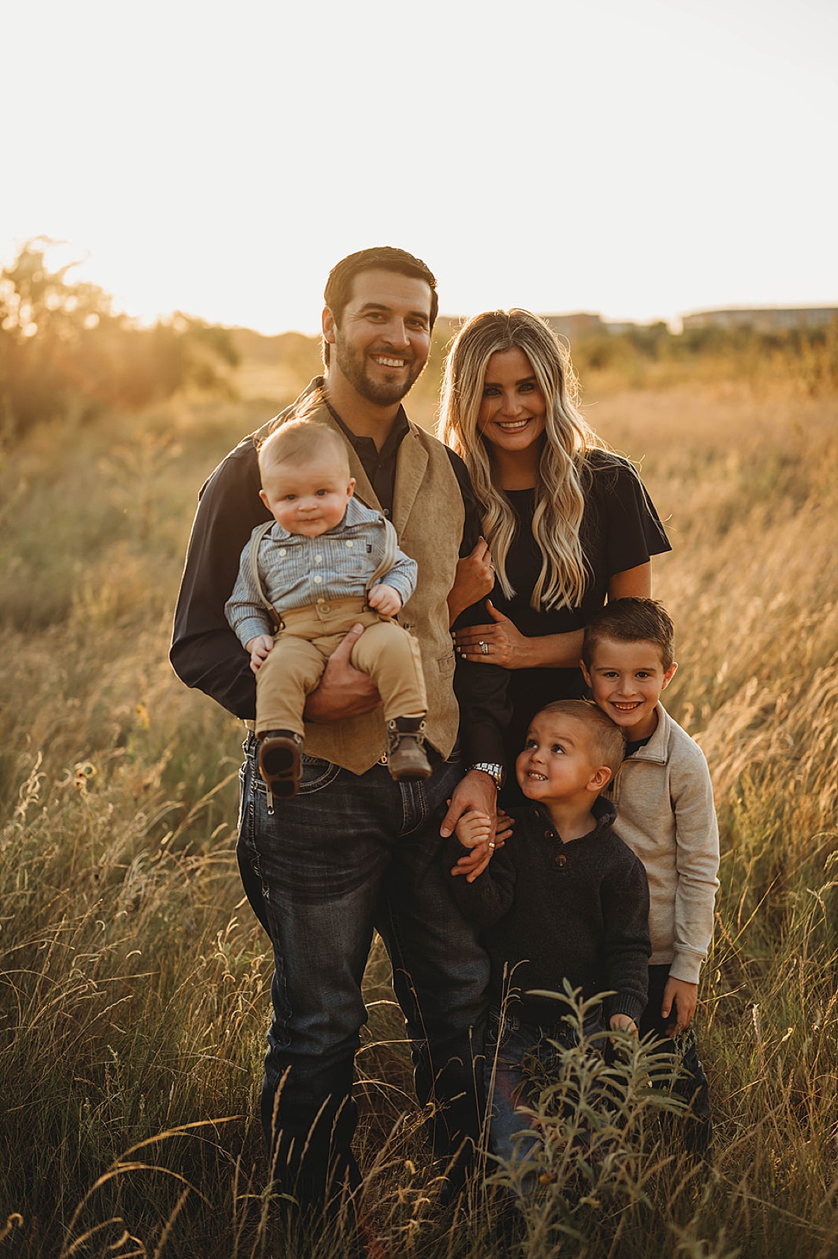 family with three little boys poses for portraits during golden hour shoot with three feather photo co.