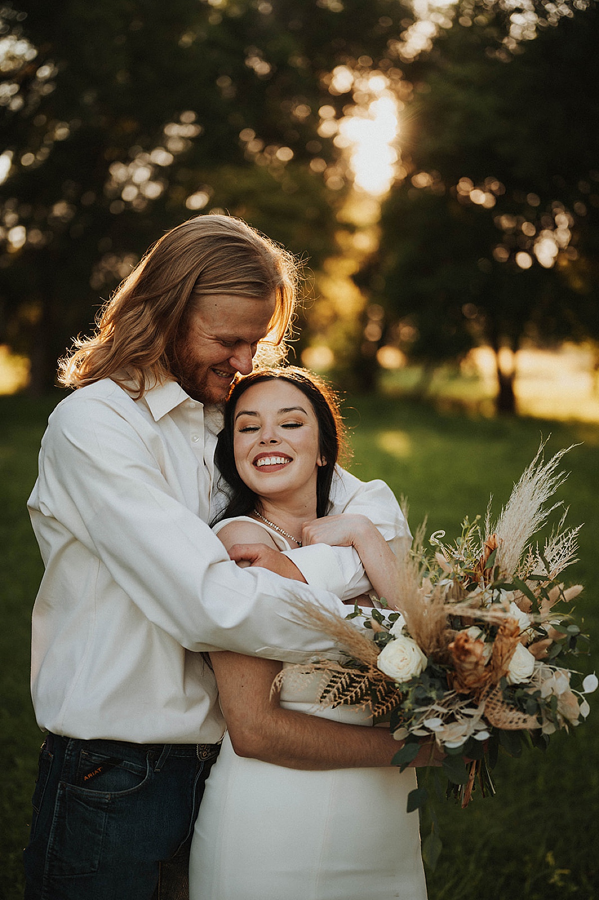 boho western bride and groom pose with dried flower bouquet after elopement shot by Three Feather Photo Co