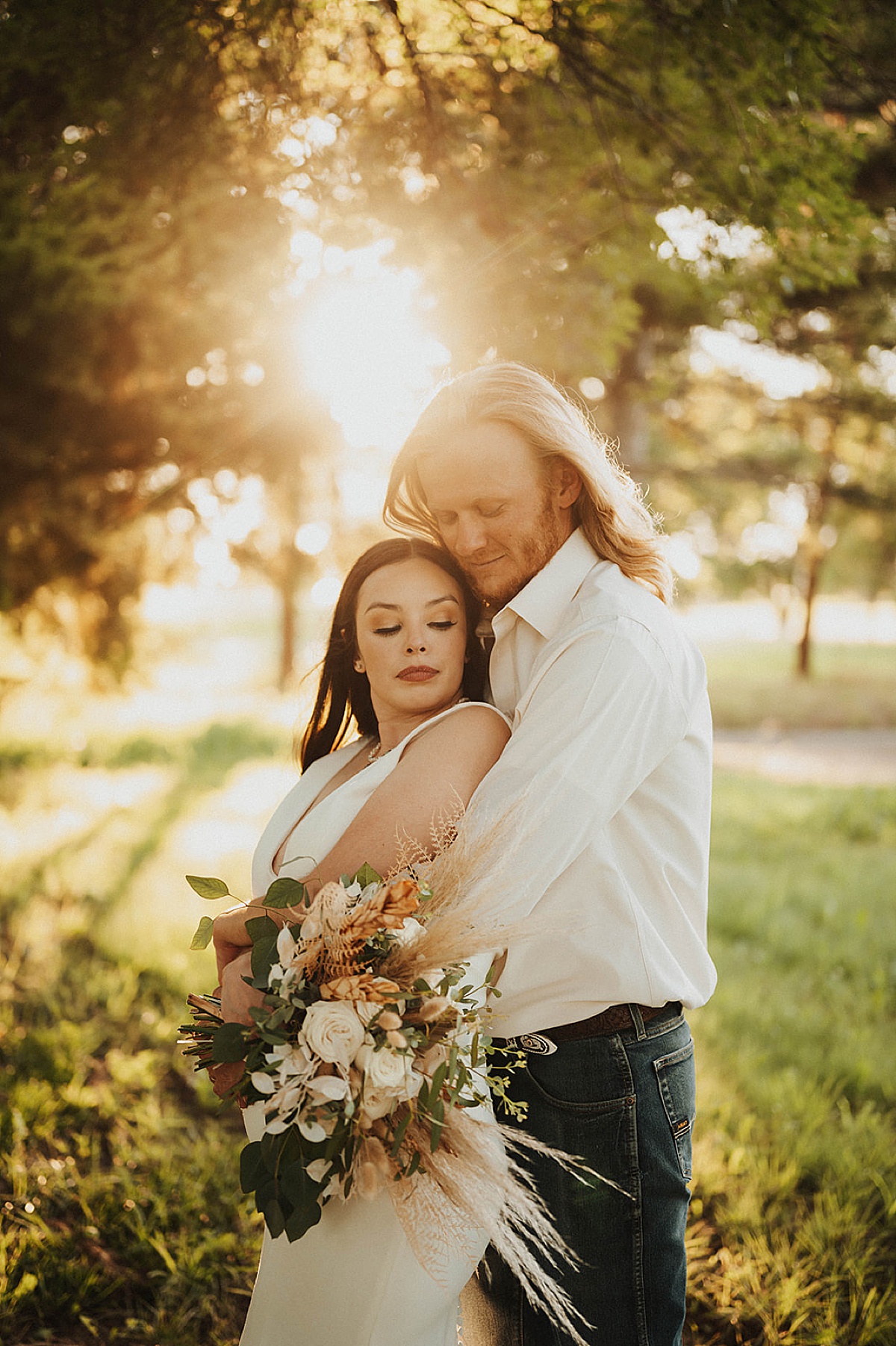 western boho couple pose with dried flower bouquet in golden hour field shot by Palo Duro Canyon Elopement Photographer