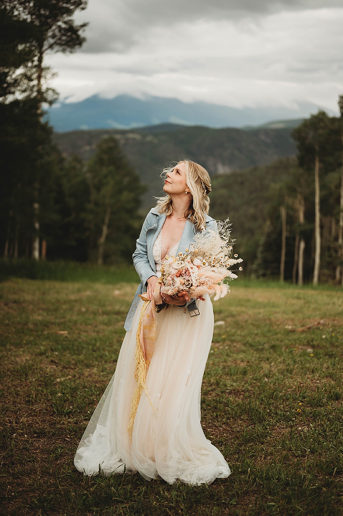 bride with boho dried flower bouquet and blue jacket poses during shoot by palo duro canyon elopement photographer