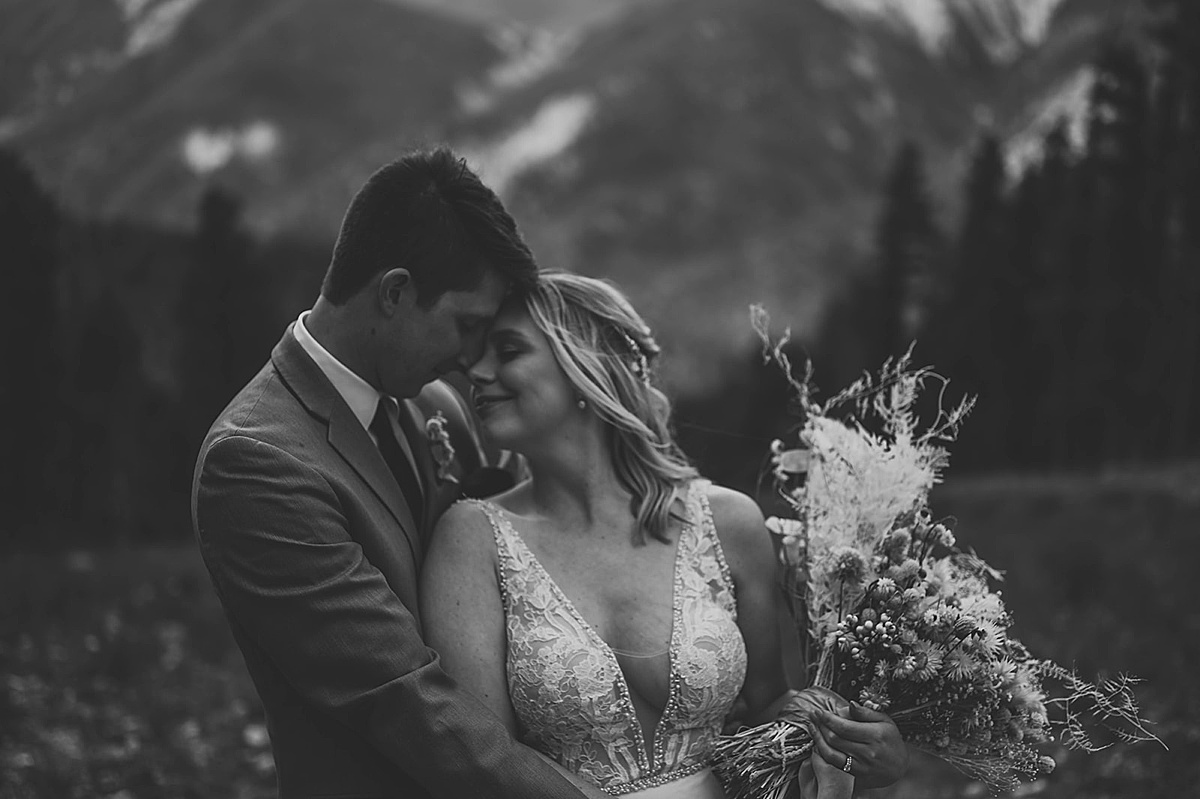 boho bride and groom pose in new mexico mountains during ceremony shot by Three Feather Photo Co