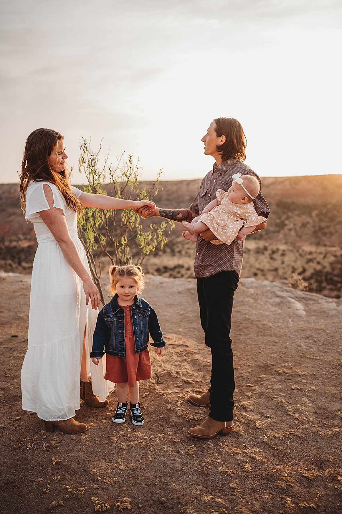 cute couple pose with their toddler daughter and baby during sunrise adventure family portraits