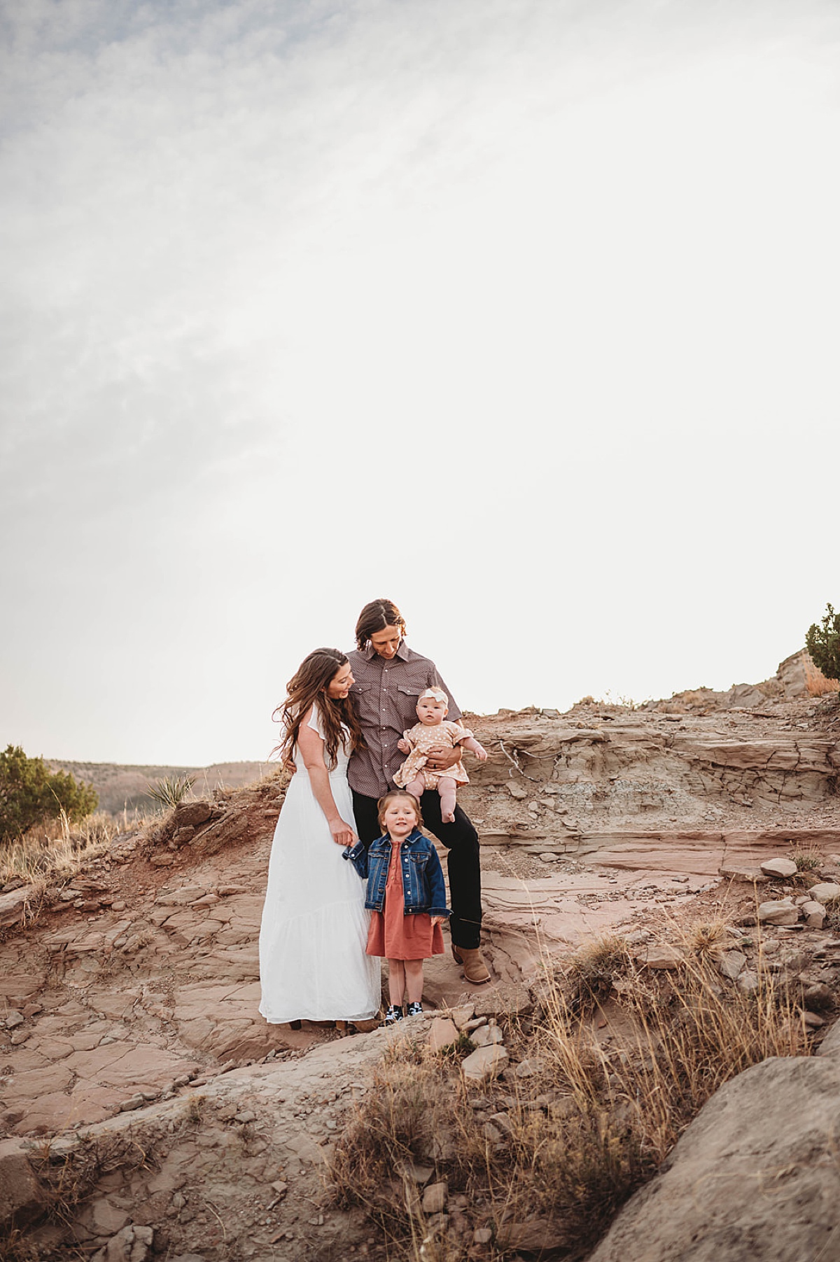 mom and dad pose with little girls during family photos shot by palo duro canyon elopement photographer