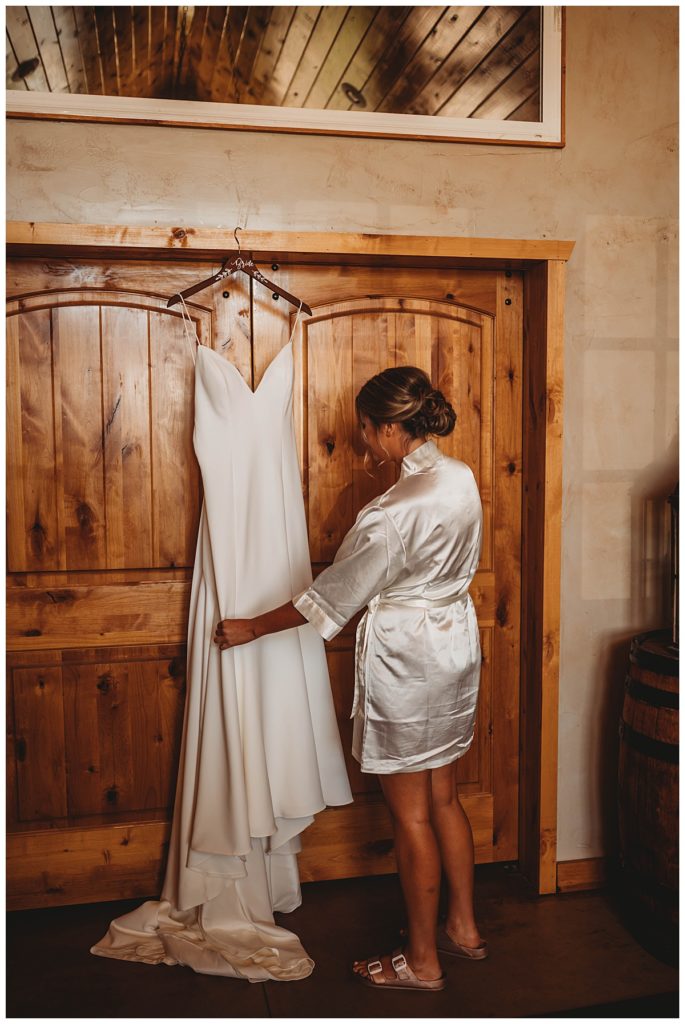 bride looks at gown by Palo Duro wedding photographer