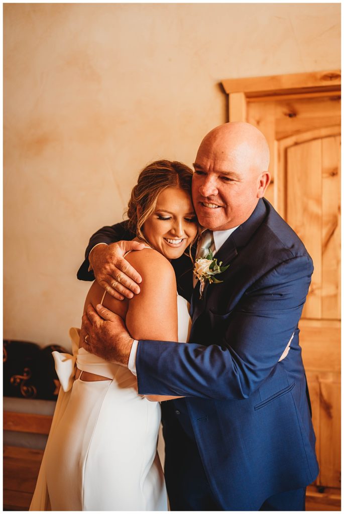 woman hugs her father in Texas ranch wedding