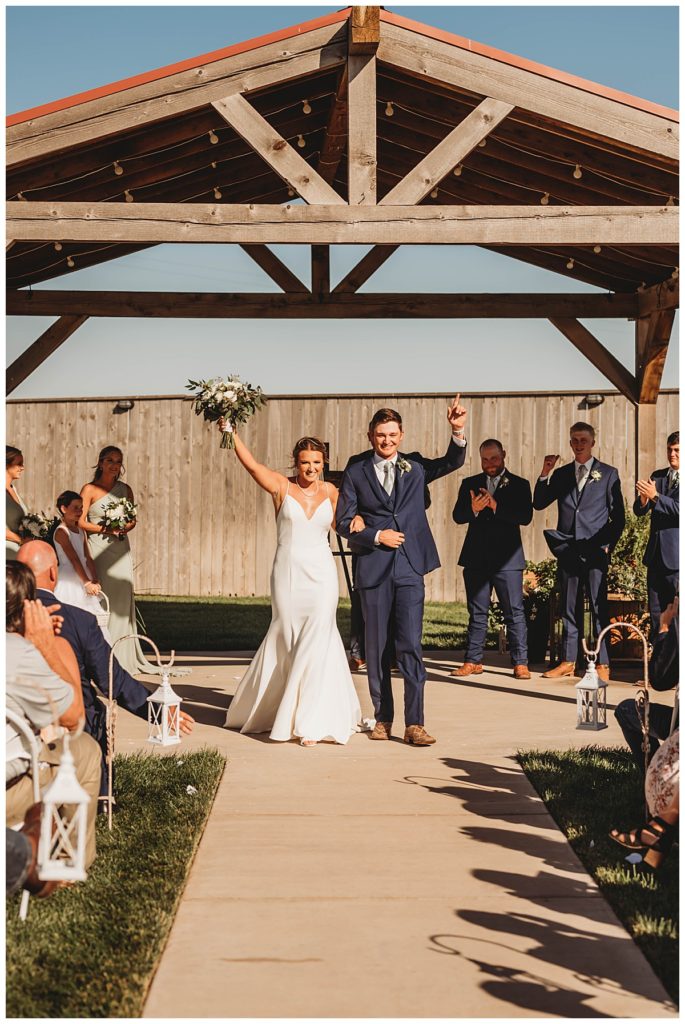 couple celebrates down aisle by Palo Duro wedding photographer