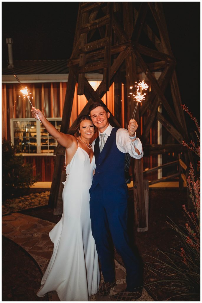 couple holds sparklers at Texas ranch wedding