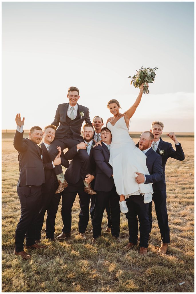groomsmen lift couple by Three Feather Photo Co.