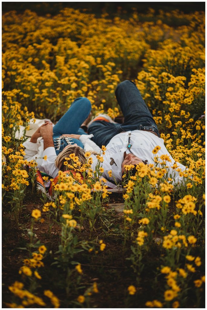 couple lays in field of yellow flowers by Palo Duro Wedding Photographer