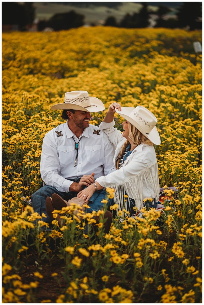 couple in cowboy hats laughs by Three Feather Photo