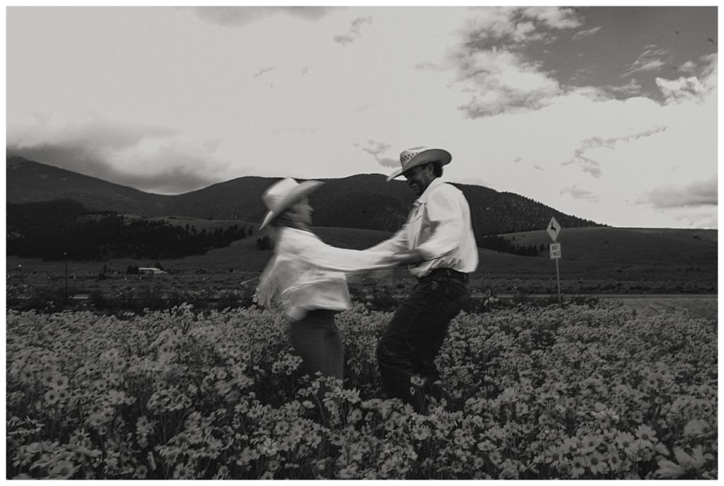 two people spinning in wildflower field at Red Rock couples session