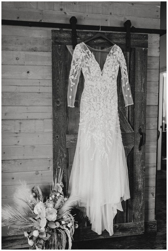 wedding dress hanging on barn door by Palo Duro wedding photographer