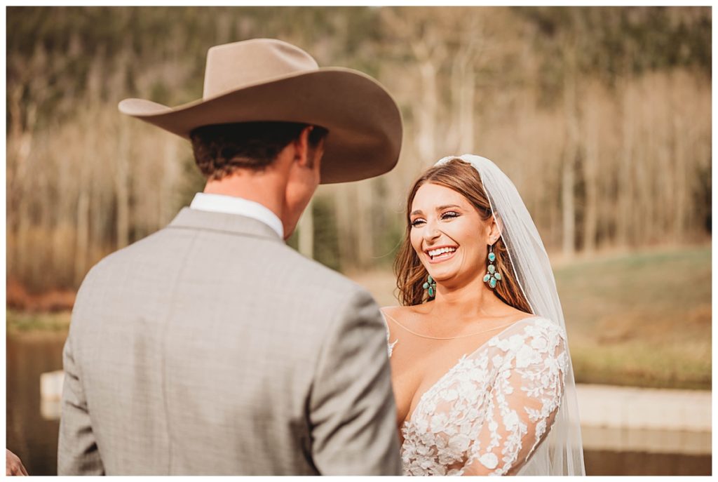 bride smiles at groom by Three Feather Photo