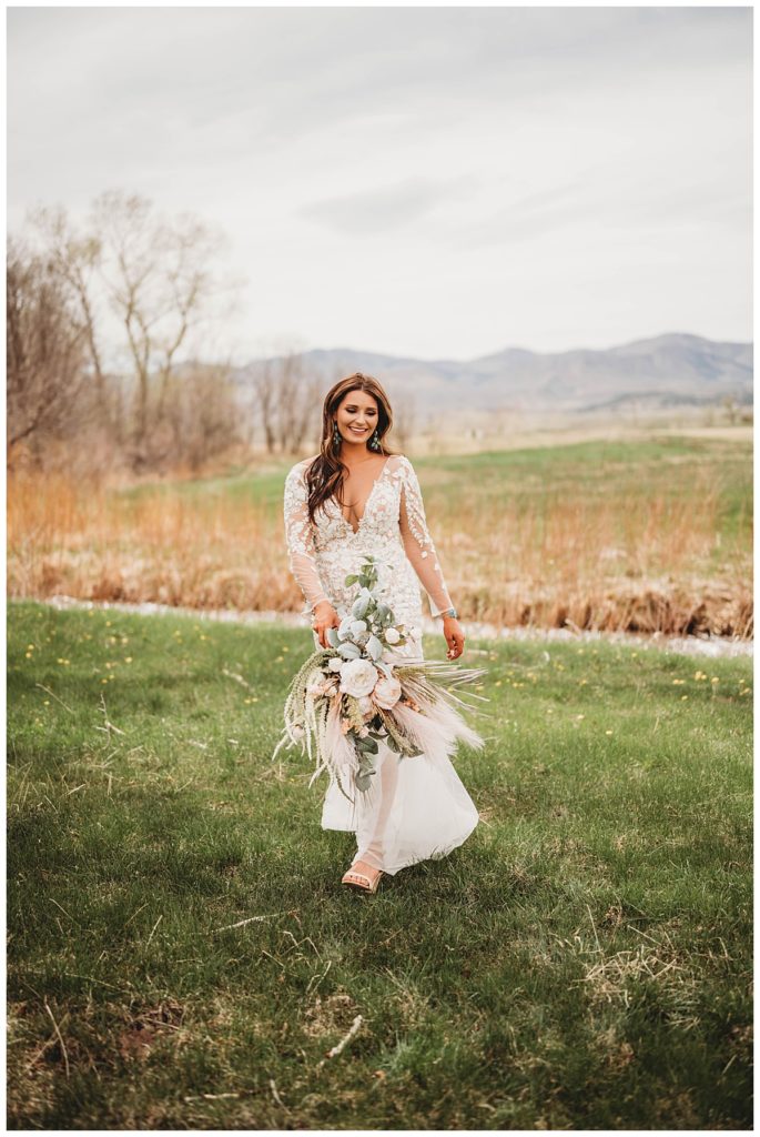 bride walking through field at Colorado cabin elopement