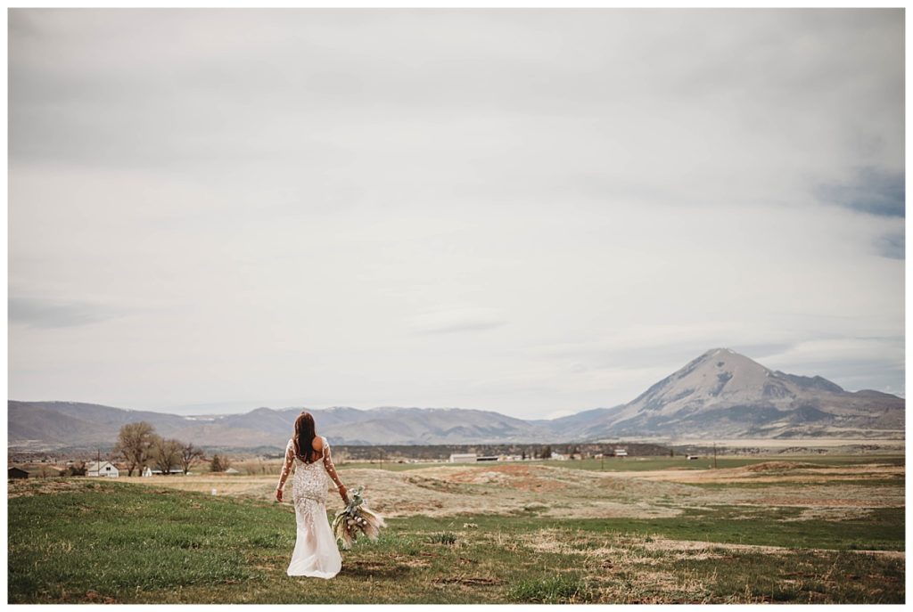 bride walking away in field by Palo Duro wedding photographer