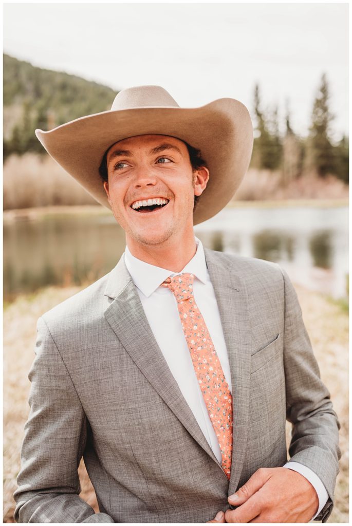 groom smiling in front of pond by Three Feather Photo