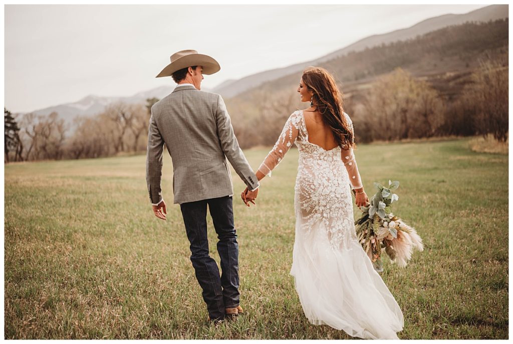 couple holding hands walking at Colorado cabin elopement