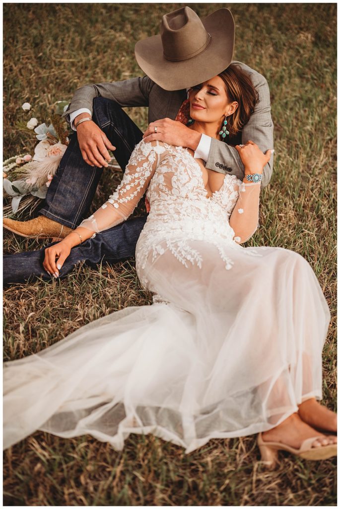 couple sitting together in field by Three Feather Photo