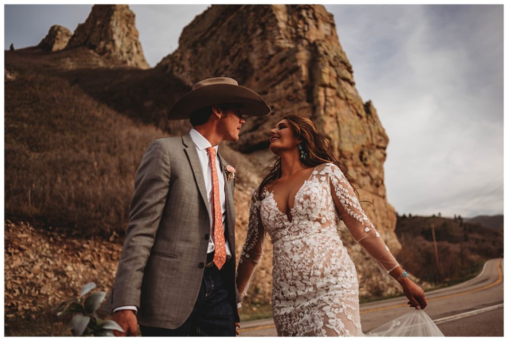 bridal couple in front of rock formation by Three Feather Photo