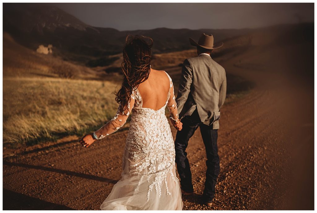 bride and groom on dirt road at Colorado cabin elopement