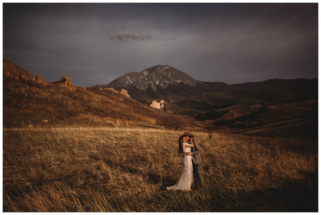 groom kissing bride's cheek in field by Palo Duro wedding photographer