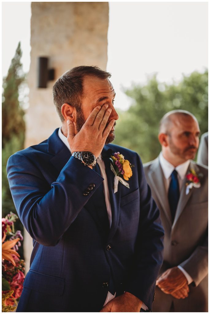 man wipes tears during ceremony by Palo Duro wedding photographer