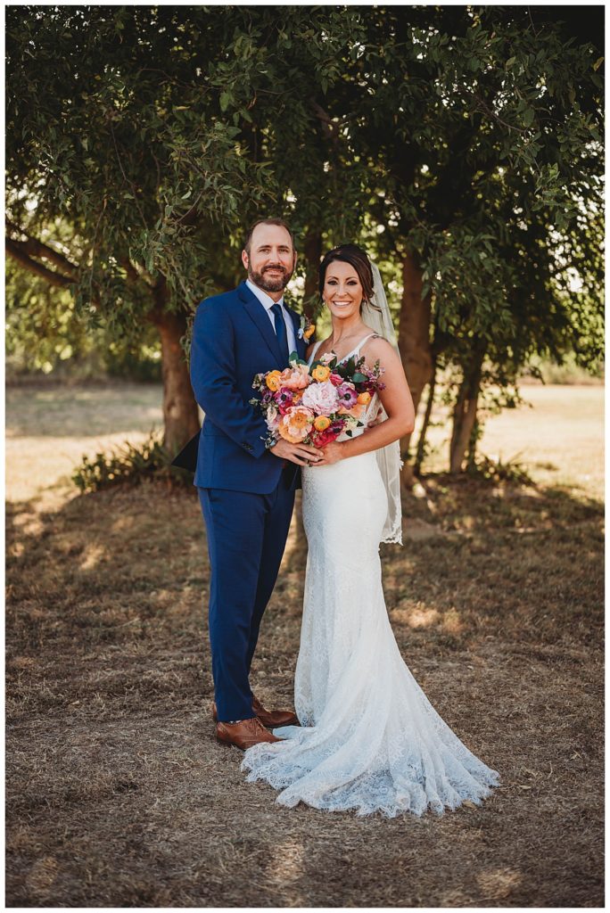 couple poses with bouquet at Austin villa wedding