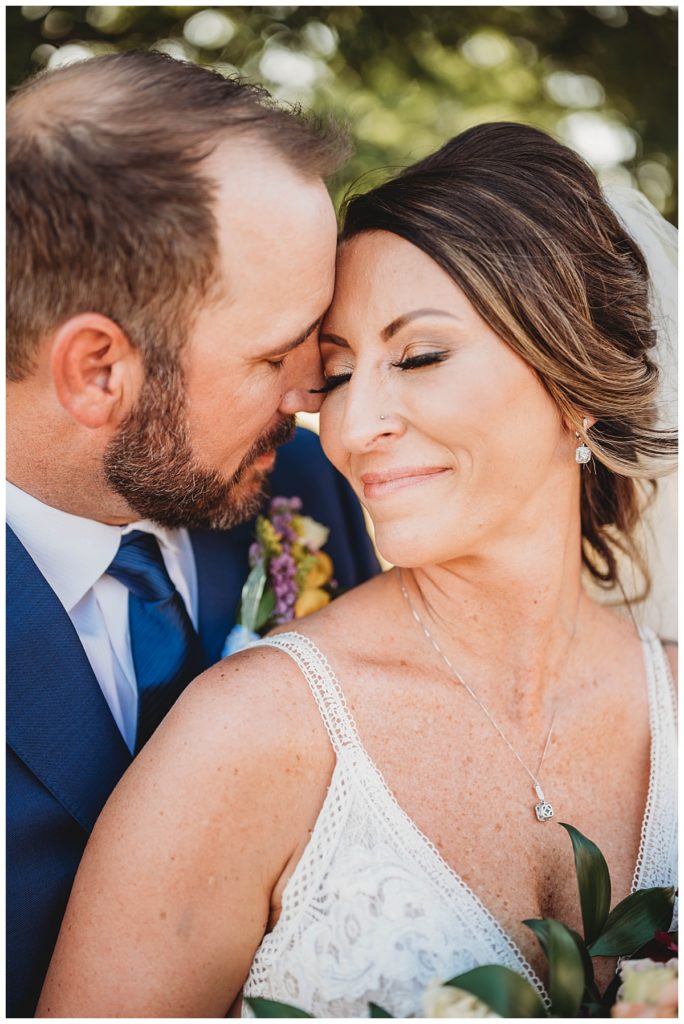 couple touches foreheads by Three Feather Photo