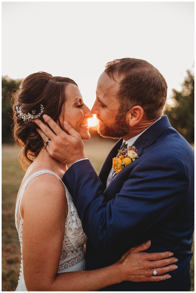 man holds woman's face with sun shining through by Palo Duro wedding photographer