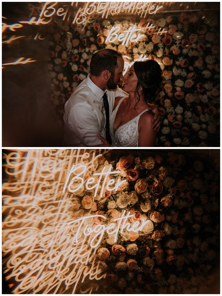 couple kisses in front of neon sign by Three Feather Photo