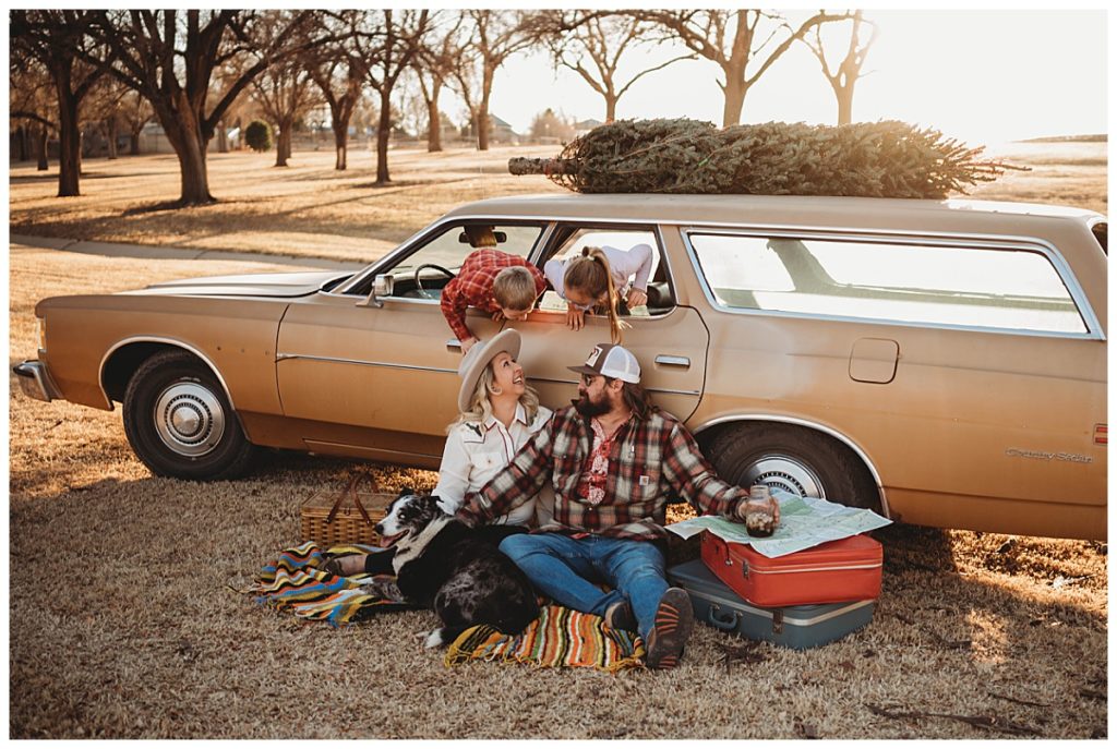 kids peek down at parents sitting on ground by Three Feather Photo