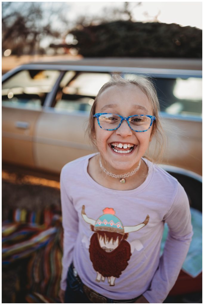 girl with blue glasses and purple shirt smiles by Palo Duro Wedding Photographer