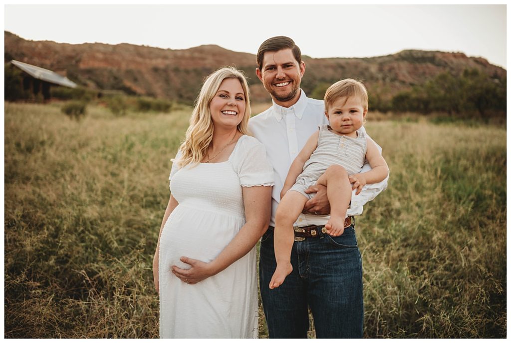 family stands together in meadow at canyon maternity photo session