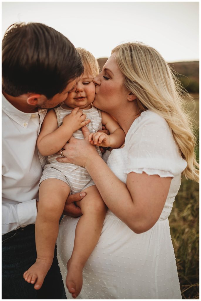parents kiss toddler's cheeks at canyon maternity shoot