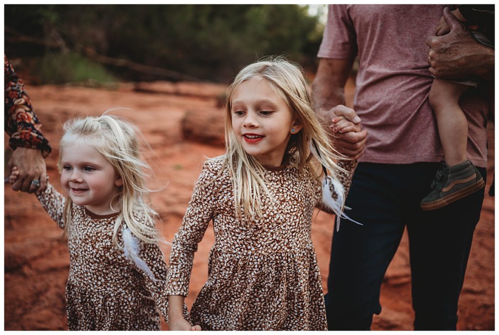 sisters hold hands in matching dresses for family portraits at Martin Nature Park