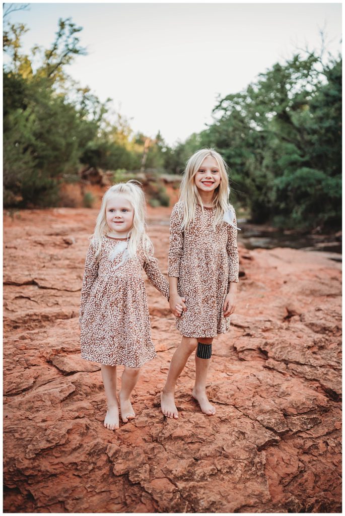 sisters hold hands together by Palo Duro wedding photographer
