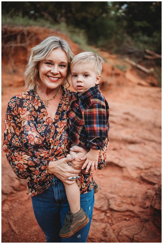 mom holds son on red rocks at family portraits at Martin Nature Park
